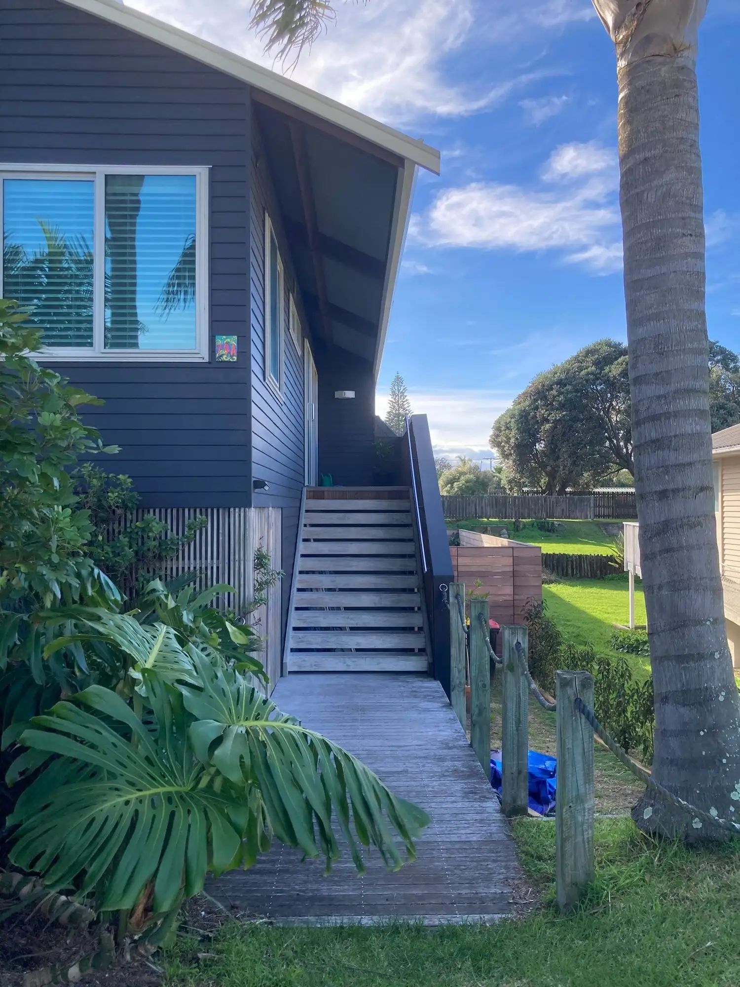 Dark weatherboard exterior with external stairs at Mount Maunganui, repainted